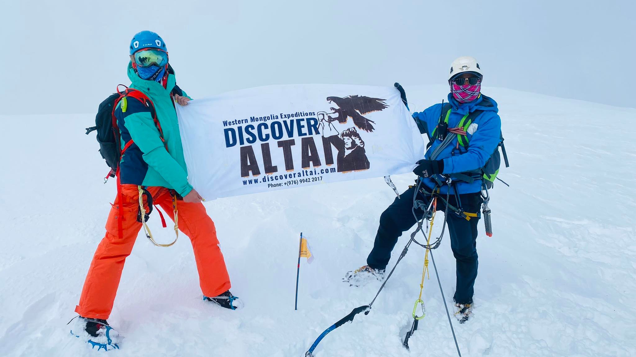 Trekker reaching the top of Khuiten Peak in the Altai Mountains