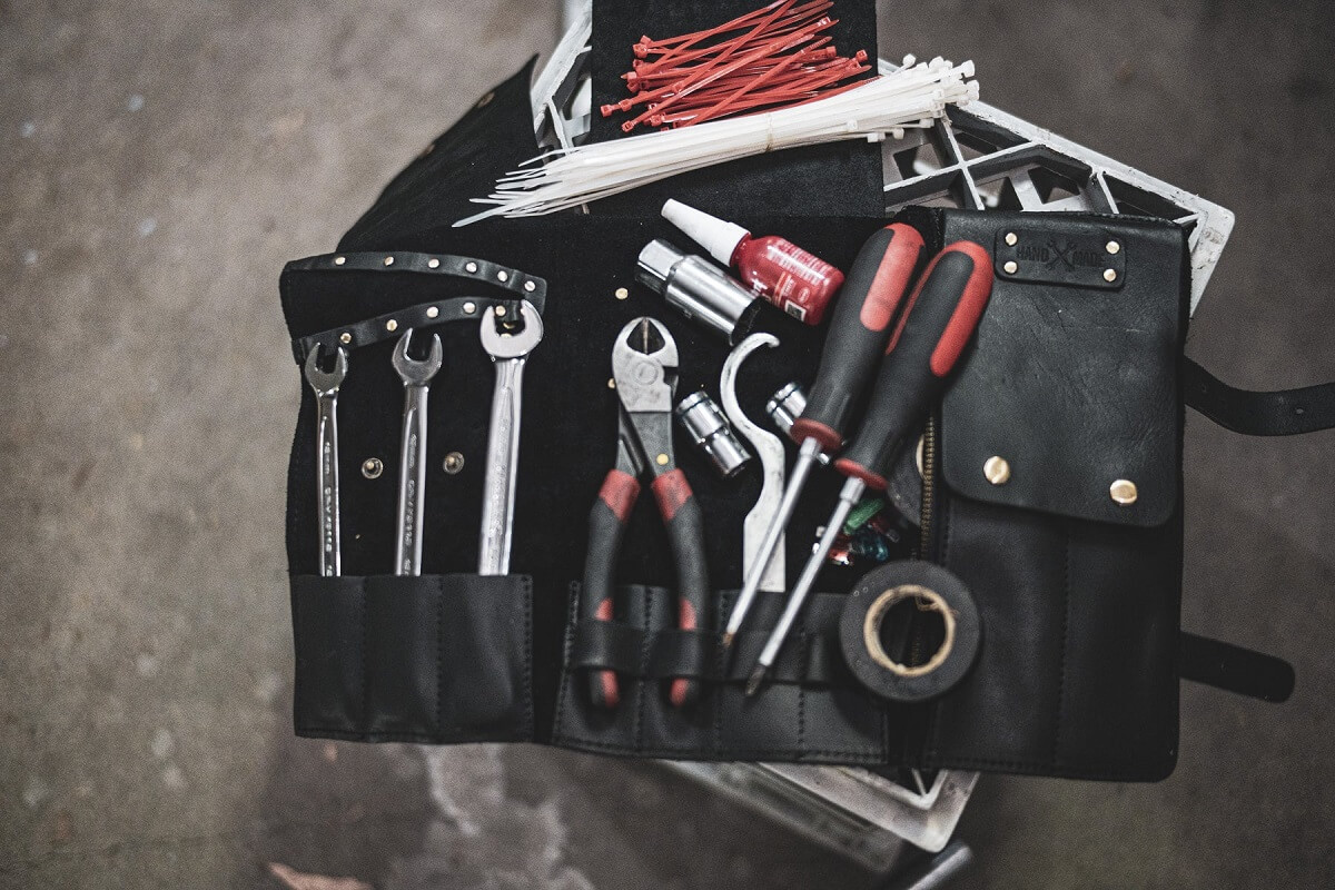 Essential tools laid out beside an adventure motorcycle ready for a Mongolia trip