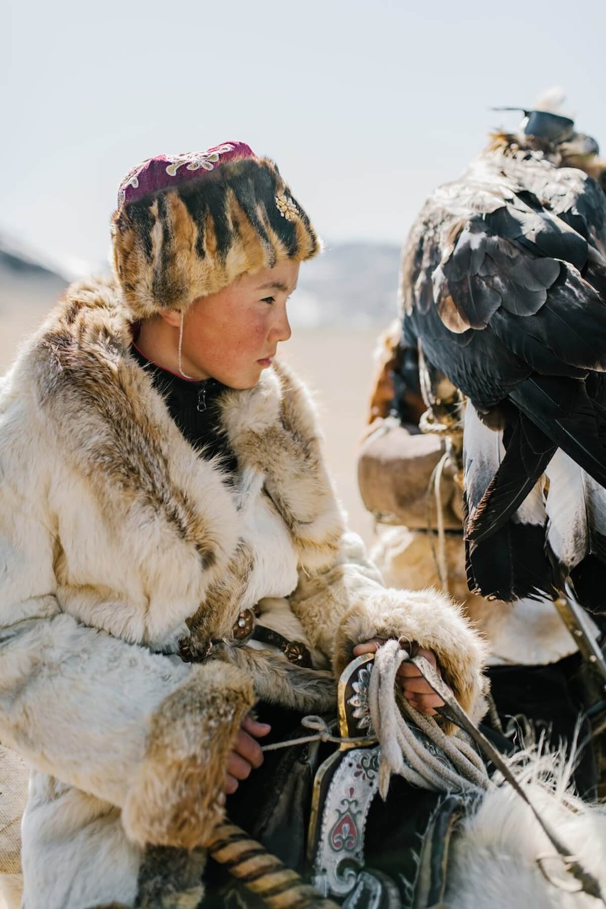 Young boy holding a golden eagle