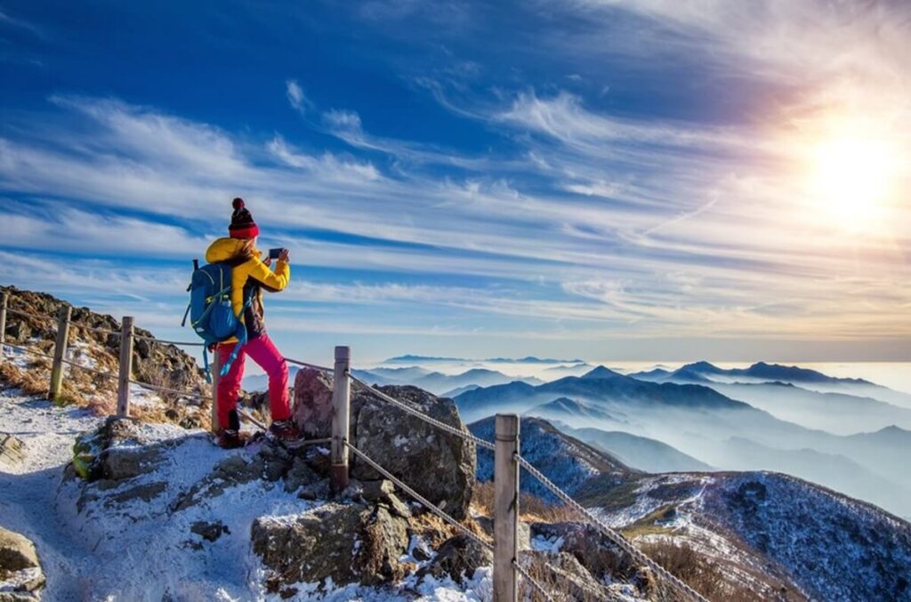young woman hiker taking photo with smartphone mountains peak winter 335224 427 1