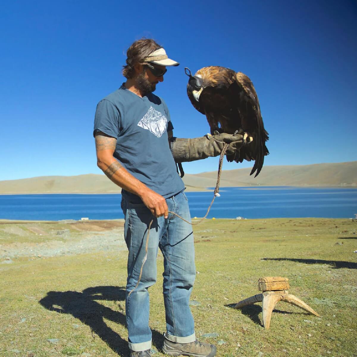 Master falconer with a trained bird of prey on the gloved fist in Central Asia.