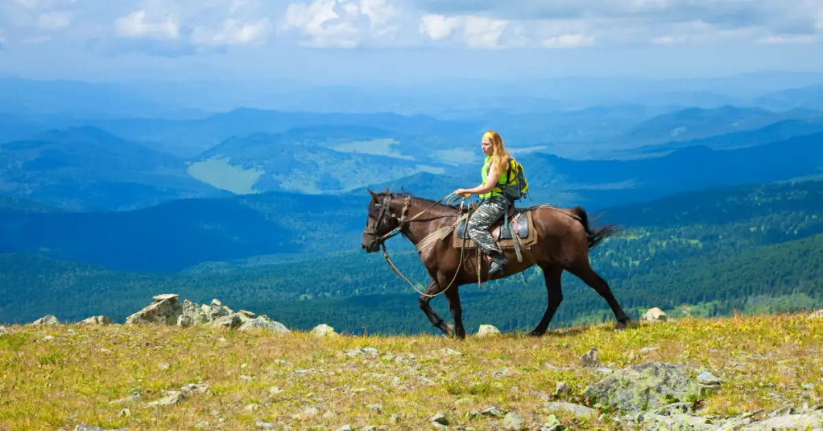 Trekkers and pack horses navigating the Altai Tavan Bogd valley system on a multi-day route.