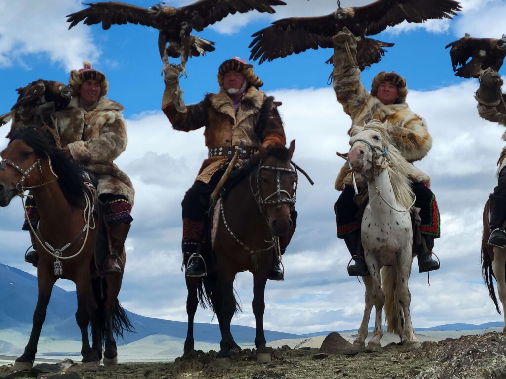 Kazakh eagle hunters with golden eagles on horseback in western Mongolia